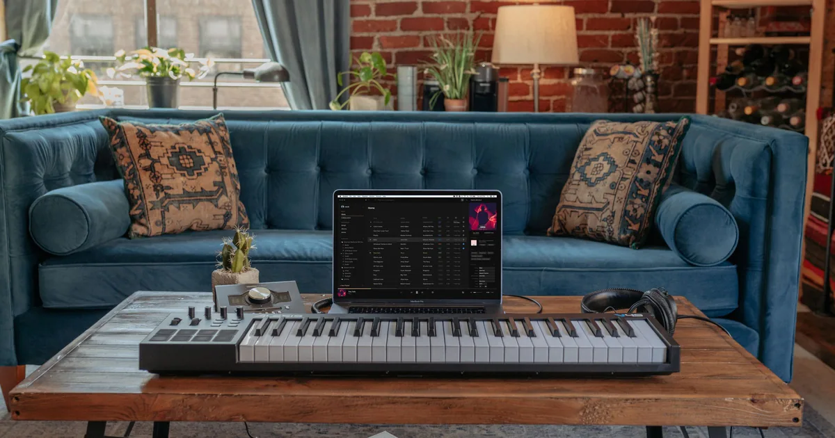 A laptop and a MIDI keyboard on a desk, the setup for the free play drum beats panel in the browser