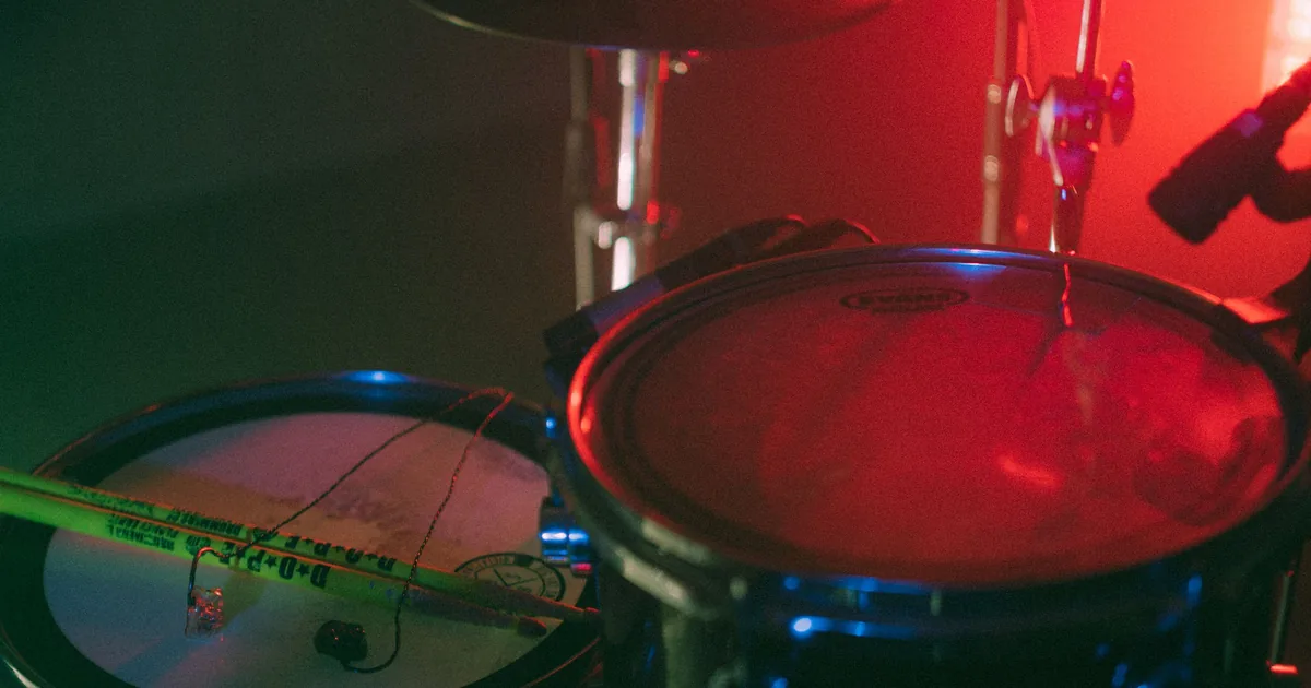 Acoustic drum kit under warm studio light, the instrument this guide teaches you to play without owning one